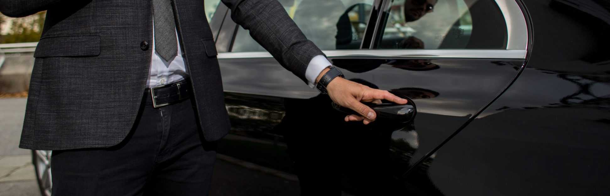 Man opening a black car limousines door